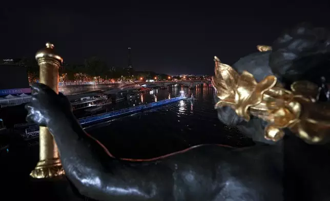 Technicians remove the pontoon for the start of the triathlon events after the event was postponed over concerns about water quality in Paris' Seine River, at the 2024 Summer Olympics, Tuesday, July 30, 2024, at the Pont Alexandre III bridge in Paris, France. (AP Photo/Vadim Ghirda)