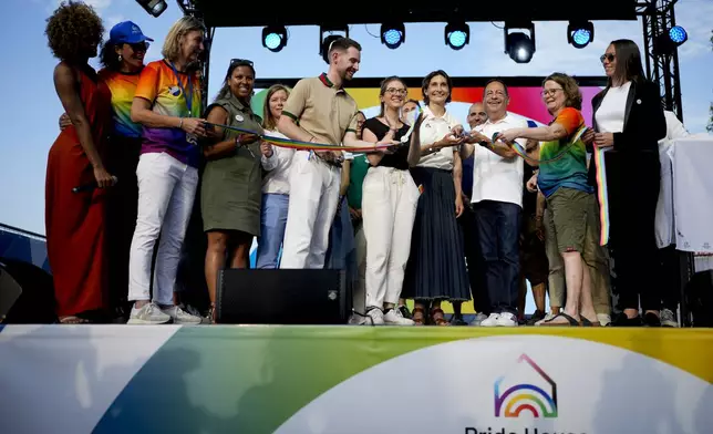 French sports minister Amelie Oudea-Castera, center, takes part in the opening ceremony of Pride House, the safe space for the LGBT+ community of athletes, during the 2024 Summer Olympics, Monday, July 29, 2024, in Paris, France. (AP Photo/Natacha Pisarenko)