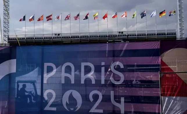 A worker drives a golf cart inside the competition venue for BMX freestyle ahead of the 2024 Summer Olympics, Friday, July 19, 2024, in Paris. (AP Photo/David Goldman)