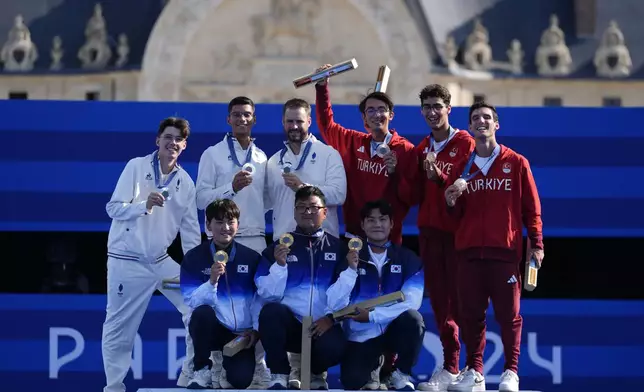 Teams France, South Korea, and Turkey celebrate during the men's team medal ceremony at the 2024 Summer Olympics, Monday, July 29, 2024, in Paris, France. (AP Photo/Rebecca Blackwell)