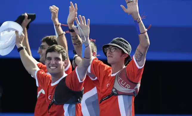 Turkey's Berkim Tumer, left, and Turkey's Mete Gazoz celebrate during the men's team bronze medal Archery competition against China at the 2024 Summer Olympics, Monday, July 29, 2024, in Paris, France. (AP Photo/Rebecca Blackwell)