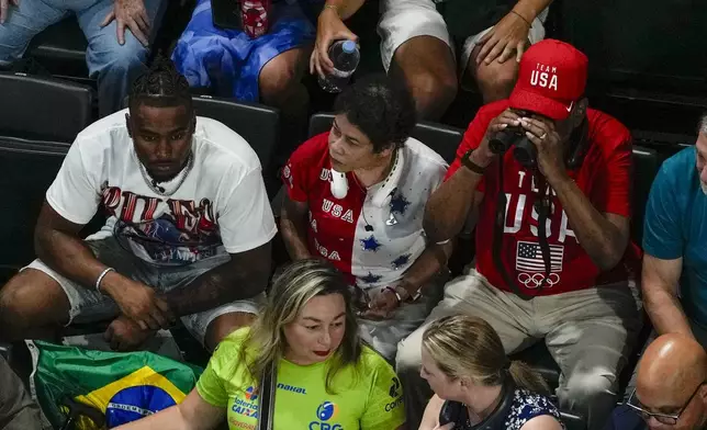 Simone Biles, of United States, husband Jonathon Owens along with her mother and farher Ron and Nellie Biles wait for the start of the women's artistic gymnastics team finals at the 2024 Summer Olympics, Tuesday, July 30, 2024, in Paris, France. (AP Photo/Morry Gash)