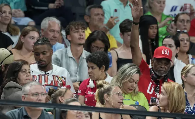 Simone Biles husband Jonathon Owens, left, and parents Nellie and Ron Biles are seen in the crowd before the women's artistic gymnastics team finals round at Bercy Arena at the 2024 Summer Olympics, Tuesday, July 30, 2024, in Paris, France. (AP Photo/Charlie Riedel)