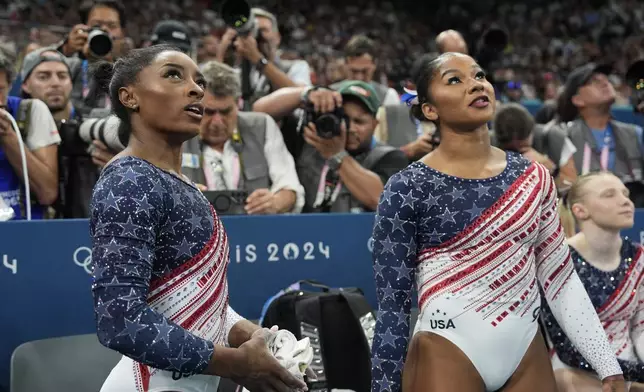 Simone Biles, and Jordan Chiles of the United States, prepare to perform on the uneven bars during the women's artistic gymnastics team finals round at Bercy Arena at the 2024 Summer Olympics, Tuesday, July 30, 2024, in Paris, France. (AP Photo/Charlie Riedel)