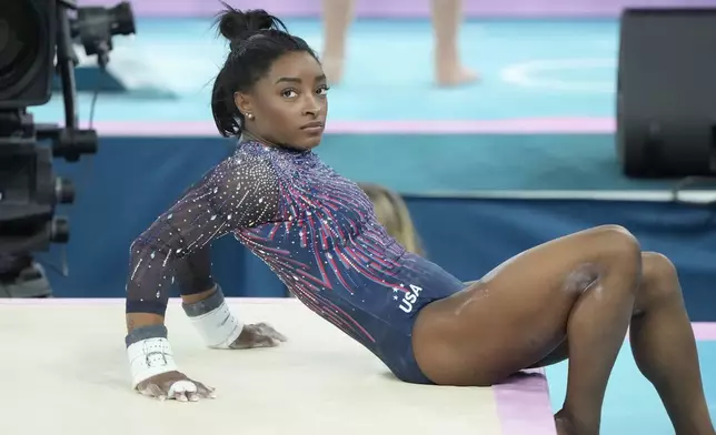 Simone Biles of the United States watches her teammates during a gymnastics training session at Bercy Arena at the 2024 Summer Olympics, Thursday, July 25, 2024, in Paris, France. (AP Photo/Charlie Riedel)