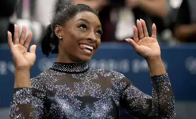 Simone Biles, of United States, celebrates after competing on the uneven bars during a women's artistic gymnastics qualification round at Bercy Arena at the 2024 Summer Olympics, Sunday, July 28, 2024, in Paris, France. (AP Photo/Charlie Riedel)