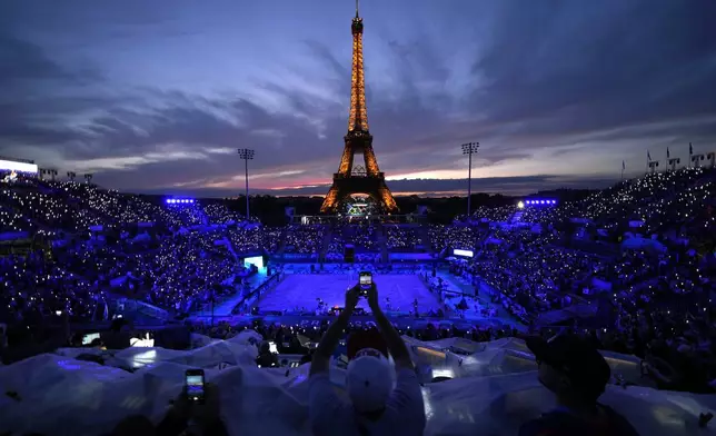 A light show at Eiffel Tower Stadium dazzles spectators prior to a beach volleyball match between The United States and Canada at the 2024 Summer Olympics, Saturday, July 27, 2024, in Paris, France. (AP Photo/Robert F. Bukaty)