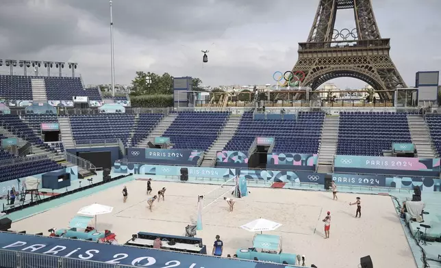 Athletes play at the Tour Eiffel stadium that will host the Beach Volleyball on the Champs-de-Mars, at the 2024 Summer Olympics in Paris, France, Wednesday July 24 2024. (Christophe Petit Tesson, Pool via AP)