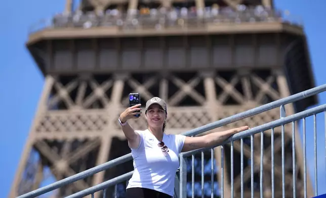 Katia Souza of Brazil takes a selfie from Eiffel Tower Stadium after a beach volleyball match at the 2024 Summer Olympics, Sunday, July 28, 2024, in Paris, France. (AP Photo/Robert F. Bukaty)