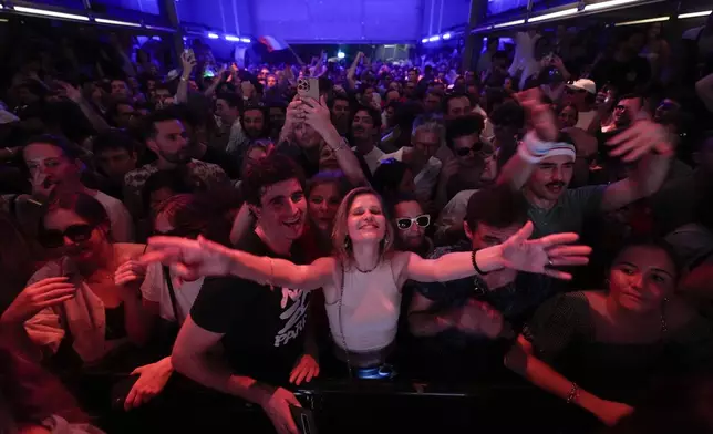 People dance as French musician Marc Cerrone performs during the DiscOlympics at Wanderlust night club during the 2024 Summer Olympics, Sunday, July 28, 2024, in Paris, France. (AP Photo/Natacha Pisarenko)