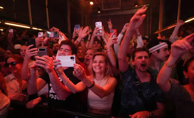 People dance as French musician Marc Cerrone performs during the DiscOlympics at Wanderlust night club during the 2024 Summer Olympics, Sunday, July 28, 2024, in Paris, France. (AP Photo/Natacha Pisarenko)