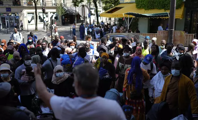 Yann Manzi addresses. The crowd during a protest at the 2024 Summer Olympics, Thursday, July 25, 2024, in Paris, France. On the eve of the grandiose opening ceremony for the Paris Olympics, police cleared out migrants sleeping in a tent camp in the capital as social and environmental advocacy groups raise attention to criticisms of the Paris Games such as the displacement of migrants and housing issues. (AP Photo/David Goldman)