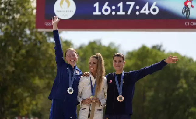 Pauline Ferrand Prevot, of France, centre, winner of the women's mountain bike cycling event, poses with her gold medal flanked by silver medallist Haley Batten, of United States, left, and bronze medallist Jenny Rissveds, of Sweden, at the 2024 Summer Olympics, Sunday, July 28, 2024, in Elancourt, France. (AP Photo/George Walker IV)