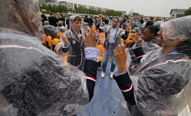 Members of the United States team do a Tiktok dance while traveling along the Seine River in Paris, France, during the opening ceremony of the 2024 Summer Olympics, Friday, July 26, 2024. (AP Photo/Ashley Landis, Pool)