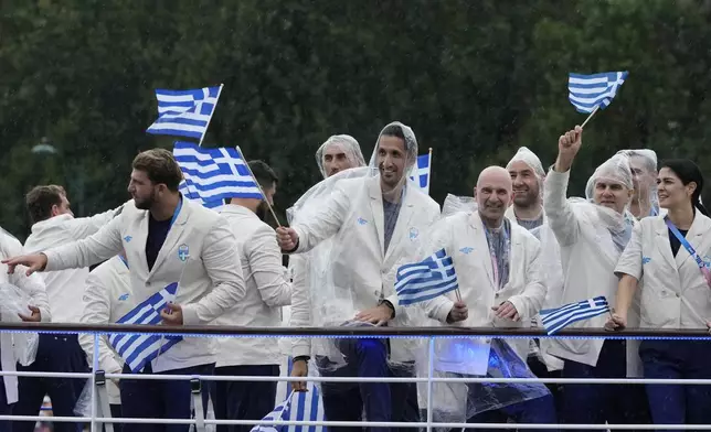 Greece's team moves down the Seine River as rain falls in Paris, France, during the opening ceremony of the 2024 Summer Olympics, Friday, July 26, 2024. (AP Photo/Morry Gash, Pool)