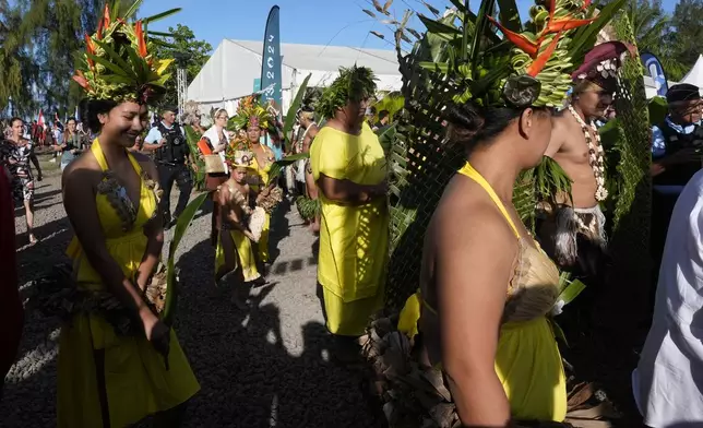 Dancers and dignitaries arrive before an opening ceremony for the 2024 Summer Olympics surfing competition Friday, July 26, 2024, in Papara, Tahiti. (AP Photo/Gregory Bull)