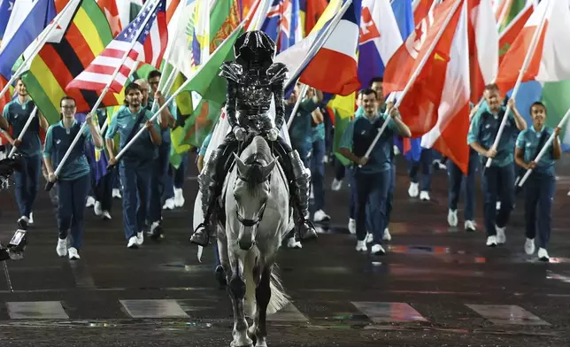 The Horsewoman rides with flags of participating countries during the opening ceremony of the 2024 Summer Olympics, Friday, July 26, 2024 in Paris, France. (Stephanie Lecocq/Pool Photo via AP)