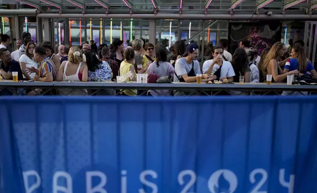 People attend the opening of Pride House, the safe space for the LGBT+ community of athletes, held on the Rosa Bonheur sur Seine boat during the 2024 Summer Olympics, Monday, July 29, 2024, in Paris, France. (AP Photo/Natacha Pisarenko)