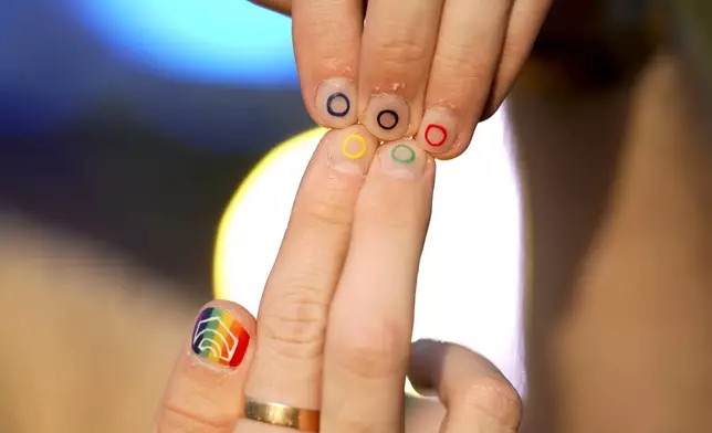 Jeremy Goupille shows his nails painted with the rainbow colors and the Olympic rings at the opening of Pride House, the safe space for the LGBT+ community of athletes, during the 2024 Summer Olympics, Monday, July 29, 2024, in Paris, France. (AP Photo/Natacha Pisarenko)