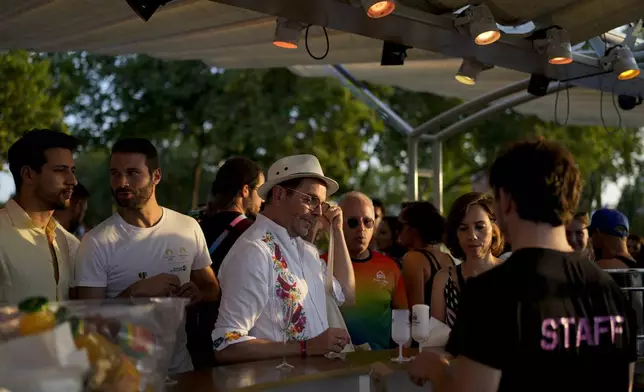 People attend the opening of Pride House, the safe space for the LGBT+ community of athletes, held on the Rosa Bonheur sur Seine boat during the 2024 Summer Olympics, Monday, July 29, 2024, in Paris, France. (AP Photo/Natacha Pisarenko)