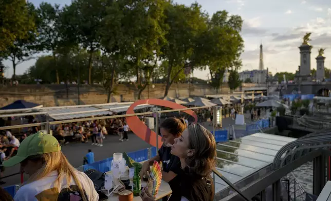 Marijo Raidy, right, attends the opening of Pride House, the safe space for the LGBT+ community of athletes, held on the Rosa Bonheur sur Seine boat during the 2024 Summer Olympics, Monday, July 29, 2024, in Paris, France. (AP Photo/Natacha Pisarenko)