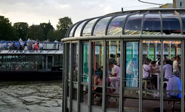 People attend the opening of Pride House, the safe space for the LGBT+ community of athletes, held on the Rosa Bonheur sur Seine boat during the 2024 Summer Olympics, Monday, July 29, 2024, in Paris, France. (AP Photo/Natacha Pisarenko)