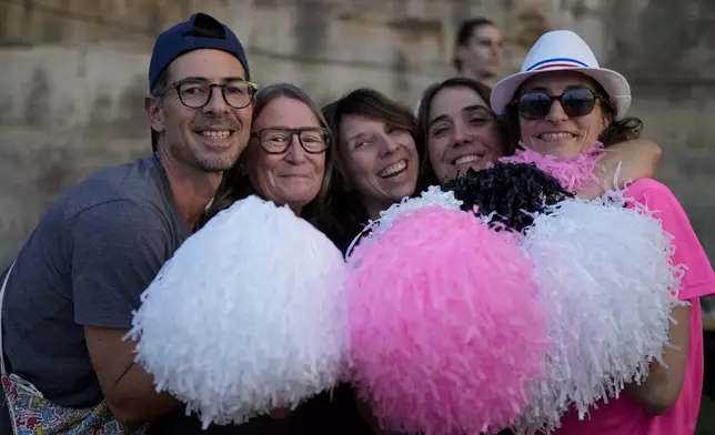 People pose for a photo as they attend the opening of Pride House, the safe space for the LGBT+ community of athletes, during the 2024 Summer Olympics, Monday, July 29, 2024, in Paris, France. (AP Photo/Natacha Pisarenko)