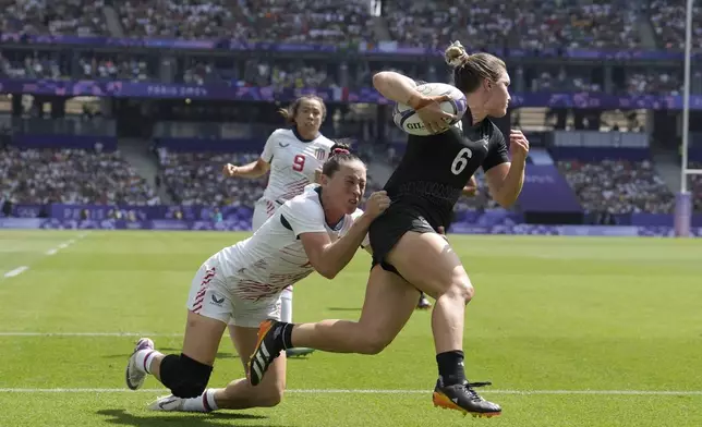 New Zealand's Michaela Blyde, right, scores a try despite a tackle by United States' Lauren Doyle during the women's semifinal Rugby Sevens match between New Zealand and the United States at the 2024 Summer Olympics, in the Stade de France, in Saint-Denis, France, Tuesday, July 30, 2024. (AP Photo/Vadim Ghirda)