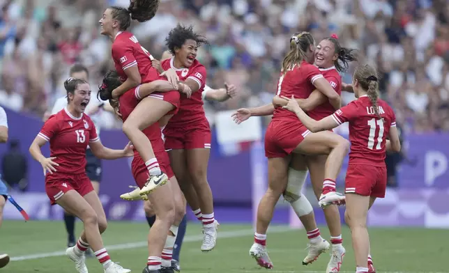 Members of the Canadian team celebrate after winning the women's semifinal Rugby Sevens match between Canada and Australia at the 2024 Summer Olympics, in the Stade de France, in Saint-Denis, France, Tuesday, July 30, 2024. Canada won the game 21-12. (AP Photo/Tsvangirayi Mukwazhi)