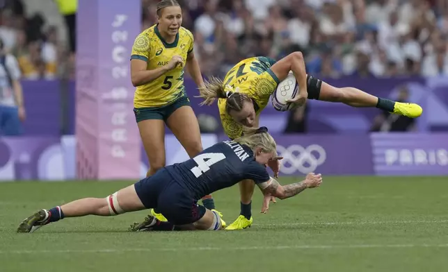 United States' Sammy Sullivan, left tackles Australia's Maddison Levi during the women's bronze medal Rugby Sevens match between the United States and Australia at the 2024 Summer Olympics, in the Stade de France, in Saint-Denis, France, Tuesday, July 30, 2024. (AP Photo/Vadim Ghirda)