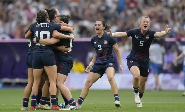 The United States team celebrate after winning the women's bronze medal Rugby Sevens match between the United States and Australia at the 2024 Summer Olympics, in the Stade de France, in Saint-Denis, France, Tuesday, July 30, 2024. The US won the game 14-12. (AP Photo/Vadim Ghirda)