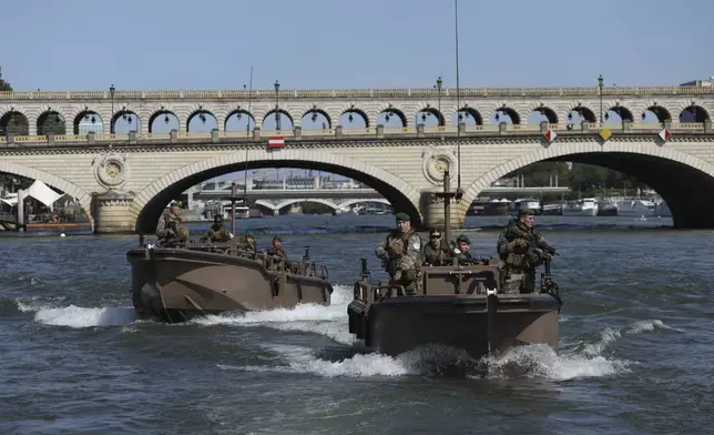 Soldiers patrol on the Seine river, Wednesday, July 17, 2024 in Paris. France's armed forces held a demonstration of the security measures planned on the River Seine, both in and out of the water, to make it safe for athletes and spectators during the opening ceremony of the Paris Olympics. Organizers have planned a parade of about 10,000 athletes through the heart of the French capital on boats on the Seine along a 6-kilometer (3.7-mile) route at sunset on July 26. (AP Photo/Aurelien Morissard)