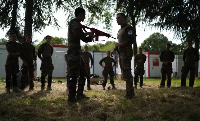 Soldiers demonstrate operational technics for close combat in a training class at a military camp set up for the Paris Olympic games Friday, July 19, 2024, Vincennes, just outside Paris, France. (AP Photo/David Goldman)