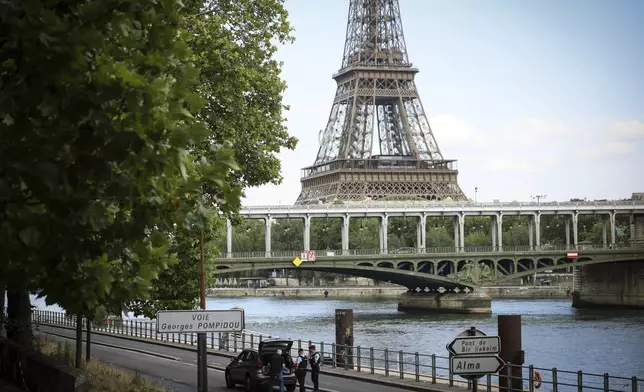 Police officers check a vehicle on the Seine river banks at the 2024 Summer Olympics, Saturday, July 20, 2024, in Paris, France. (AP Photo/Thomas Padilla)