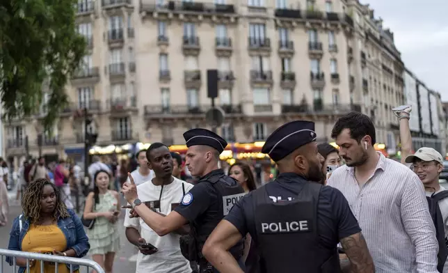 Police check the public for credentials to enter a security perimeter near the Eiffel Tower ahead of the 2024 Summer Olympics, Saturday, July 20, 2024, in Paris. (AP Photo/David Goldman)