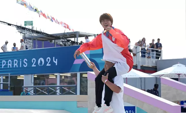 Yuto Horigome, of Japan, is carried by his coach after winning the gold medal in the men's skateboard street final at the 2024 Summer Olympics, Monday, July 29, 2024, in Paris, France. (AP Photo/Frank Franklin II)