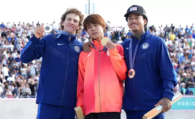 Gold medalist Yuto Horigome, of Japan, center, poses with silver medalist Jagger Eaton, of the United States, left, and bronze medalist Nyjah Huston, of the United States, after the men's skateboard street final at the 2024 Summer Olympics, Monday, July 29, 2024, in Paris, France. (AP Photo/Frank Franklin II)