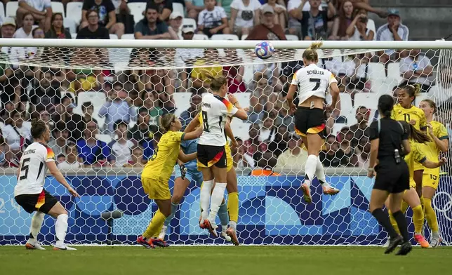 Germany's Lea Schueller, right in mid-air, heads the ball to score her side's second goal during the women's Group B soccer match between Germany and Australia at the Velodrome stadium, during the 2024 Summer Olympics, Thursday, July 25, 2024, in Marseille, France. (AP Photo/Daniel Cole)