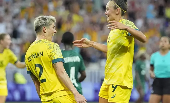 Australia's Michelle Heyman, left, celebrates scoring her side's 6th goal with Caitlin Foord during a women's group B soccer match between Zambia and Australia at the 2024 Summer Olympics, Sunday, July 28, 2024, in Nice, France. (AP Photo/Julio Cortez)