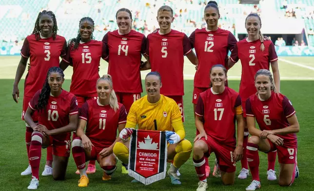 Canada team pose for a group photo prior to the women's Group A soccer match between Canada and New Zealand at Geoffroy-Guichard stadium during the 2024 Summer Olympics, Thursday, July 25, 2024, in Saint-Etienne, France. (AP Photo/Silvia Izquierdo)