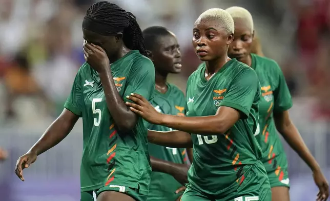 Zambia's Pauline Zulu, left, walks with teammate Hellen Chanda after she was given a red card by referee Ramon Abatti, of Brazil, during a women's group B match between the United States and Zambia at Nice Stadium at the 2024 Summer Olympics, Thursday, July 25, 2024, in Nice, France. (AP Photo/Julio Cortez)