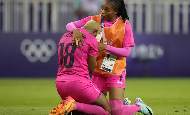 Zambia's goalkeeper Ngambo Musole, left, is comforted by goalkeeper Catherine Musonda after a women's group B soccer match between Zambia and Australia at the 2024 Summer Olympics, Sunday, July 28, 2024, in Nice, France. Australia won 6-5. (AP Photo/Julio Cortez)