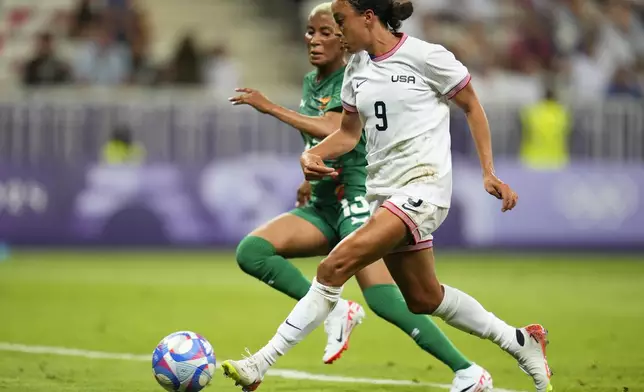 United States' Mallory Swanson (9) scores her side's third goal in front of Zambia's Martha Tembo during a women's group B match between the United States and Zambia at Nice Stadium at the 2024 Summer Olympics, Thursday, July 25, 2024, in Nice, France. (AP Photo/Julio Cortez)