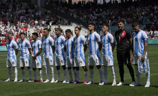 Argentina's starting players listen the national anthems prior to the Men's Group B soccer match between Argentina and Morocco at Geoffroy-Guichard Stadium during the 2024 Summer Olympics, Wednesday, July 24, 2024, in Saint-Etienne, France. (AP Photo/Silvia Izquierdo)