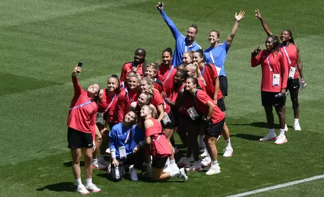 Canada's players pose for photos on the pitch at Geoffroy-Guichard Stadium ahead of the 2024 Summer Olympics, Tuesday, July 23, 2024, in Saint-Etienne, France. Canada is scheduled to play New Zealand on Thursday, July 25. (AP Photo/Silvia Izquierdo)