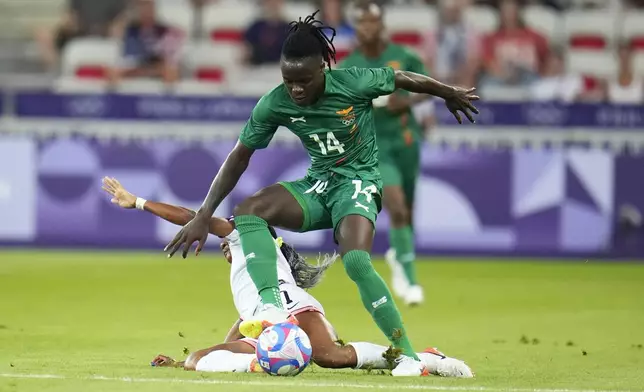 Zambia's Prisca Chilufya (14) is challenged by United States' Crystal Dunn during a women's group B match between the United States and Zambia at Nice Stadium at the 2024 Summer Olympics, Thursday, July 25, 2024, in Nice, France. (AP Photo/Julio Cortez)