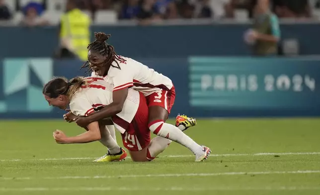 Canada's Vanessa Gille, left, celebrates with Kadeisha Buchanan their side's 2-1 win during the women's Group A soccer match between Canada and France at Geoffroy-Guichard stadium during the 2024 Summer Olympics, Sunday, July 28, 2024, in Saint-Etienne, France. (AP Photo/Silvia Izquierdo)