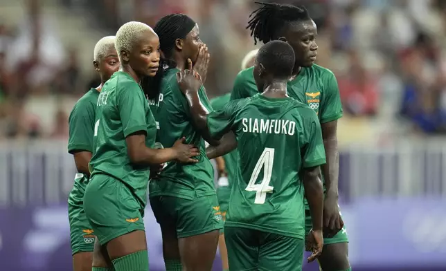 Zambia athletes gather around Pauline Zulu, center, after she was given a red card by referee Ramon Abatti, of Brazil, during a women's group B match between the United States and Zambia at Nice Stadium at the 2024 Summer Olympics, Thursday, July 25, 2024, in Nice, France. (AP Photo/Julio Cortez)