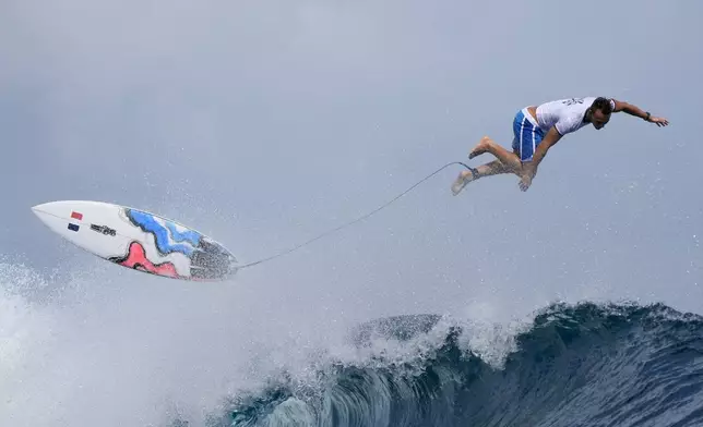 Kauli Vaast, of France, falls off a wave on a training day ahead of the 2024 Summer Olympics surfing competition Thursday, July 25, 2024, in Teahupo'o, Tahiti. (AP Photo/Gregory Bull)