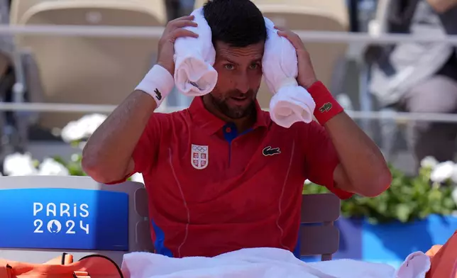 Serbia's Novak Djokovic cools off during a break as he plays Spain's Rafael Nadal during their men's singles second round match at the 2024 Summer Olympics, Monday, July 29, 2024, at the Roland Garros stadium in Paris, France. (AP Photo/Andy Wong)